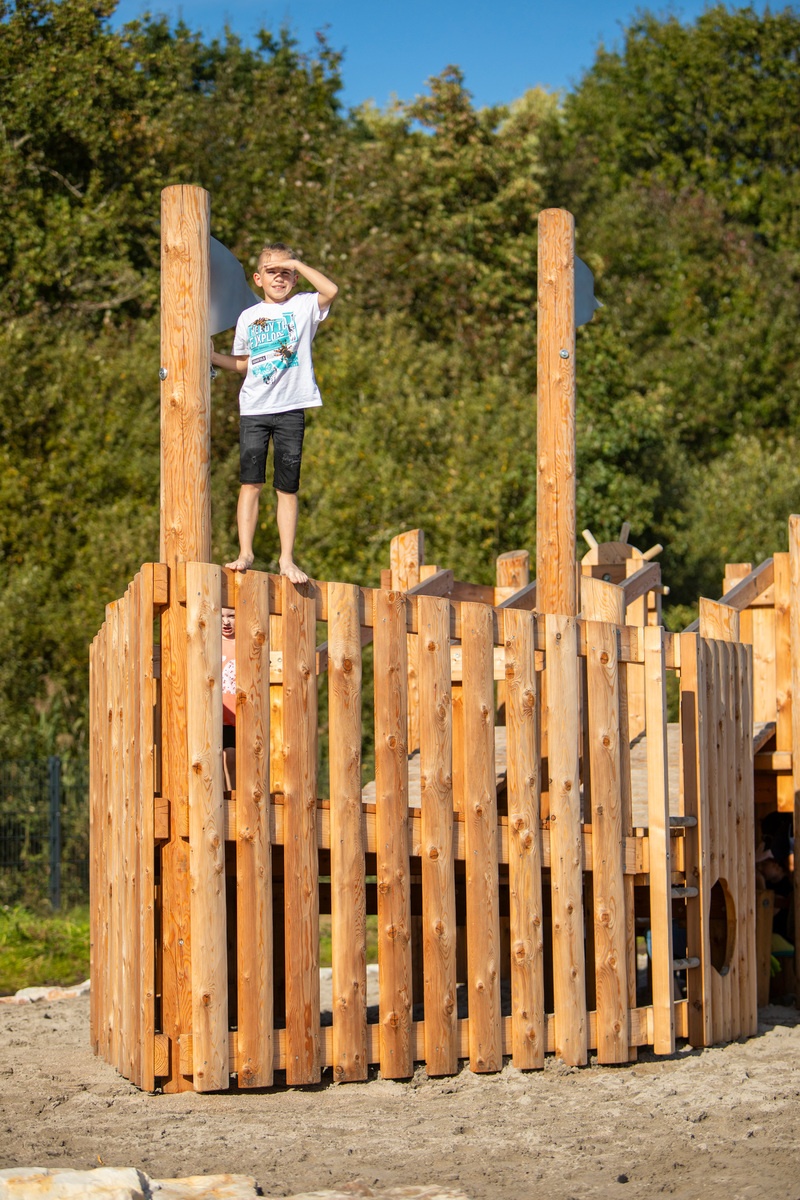 Kind steht auf einem Spielschiff aus Holz, dem "kleinen Zweimaster", am Bostalsee.