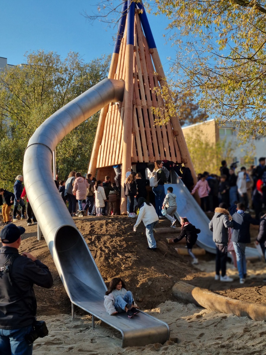 Kinder der Christian-Morgenstern-Grundschule erobern bei der Eröffnung des neuen Spielplatzes den Pyramidenturm mit Rutschen.  