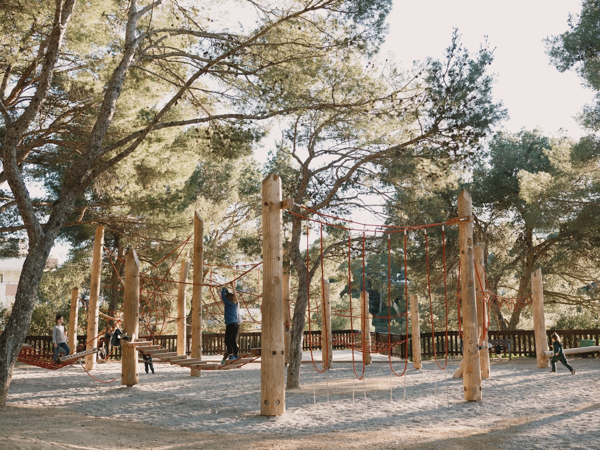 Naturspielplatz im Park Castell de Bellver auf Mallorca mit Kletterwald aus Robinienholz unter Pinien.
