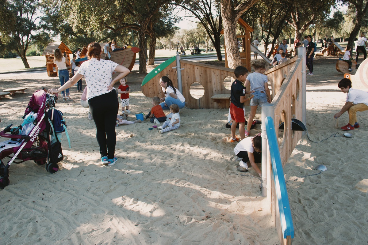 Kinder spielen an einer Raupe Variante 01 aus Holz im Sand