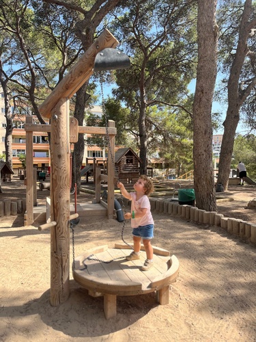 Child standing on a round mud table and playing with sand on a Richter rotating crane.